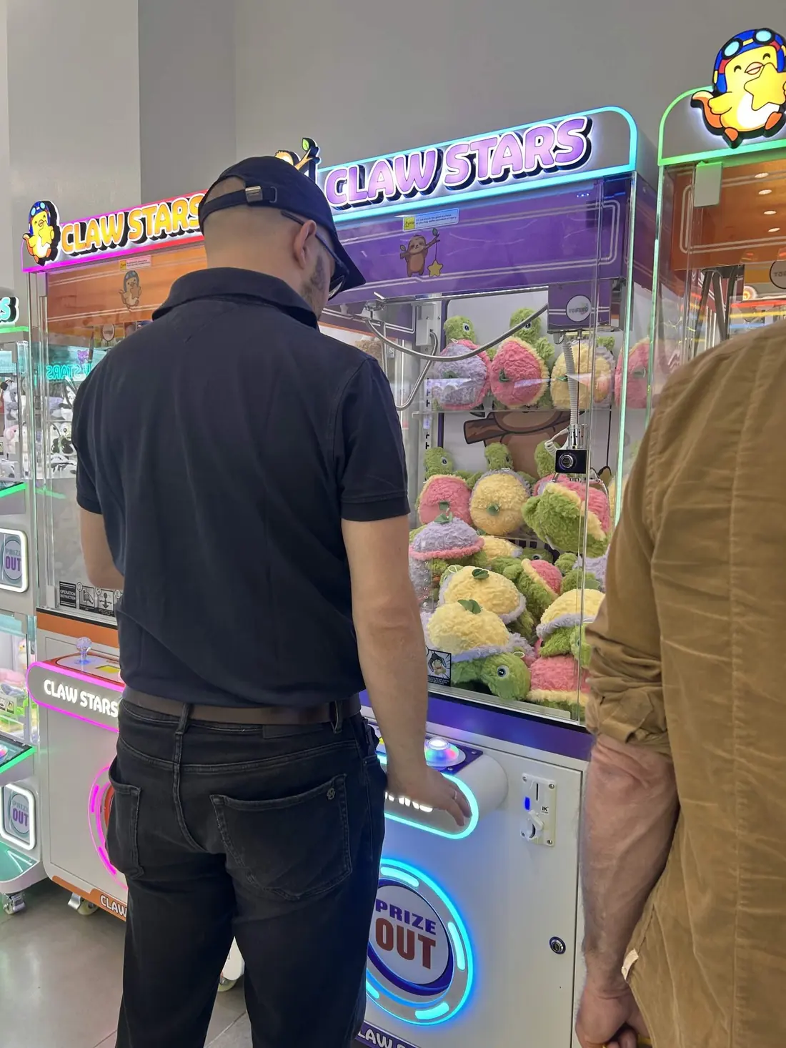 A player lining up a grab at one of the claw machines